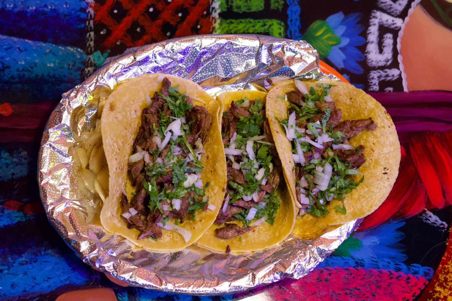 Tacos topped with cilantro and onions